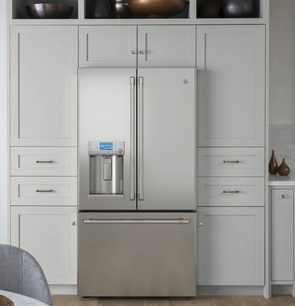 Stainless steel French door refrigerator in a kitchen with gray cabinets