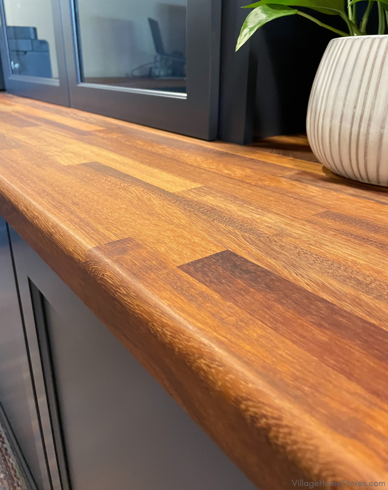 Closeup image of walnut stained wood countertop on blue cabinetry in a homeoffice