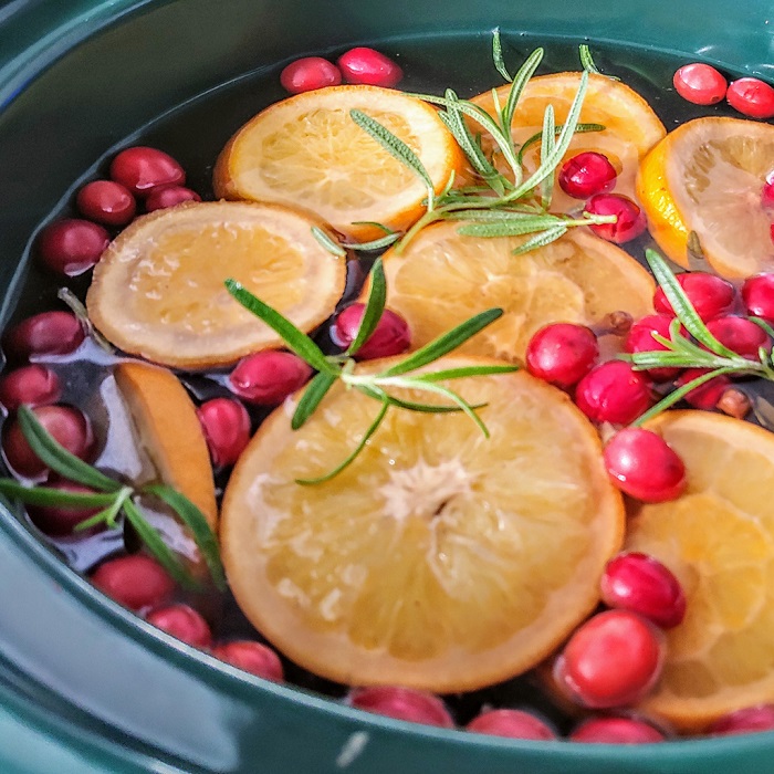 Pot of potpourri mixed with oranges, cranberries, and other garnish.