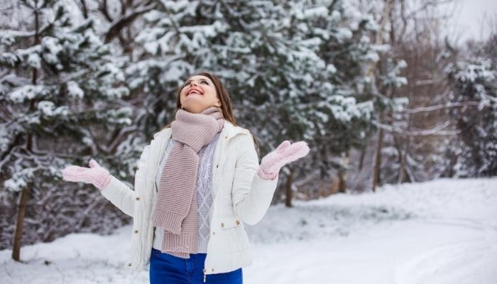 Woman with head tilt back smiling in the snow
