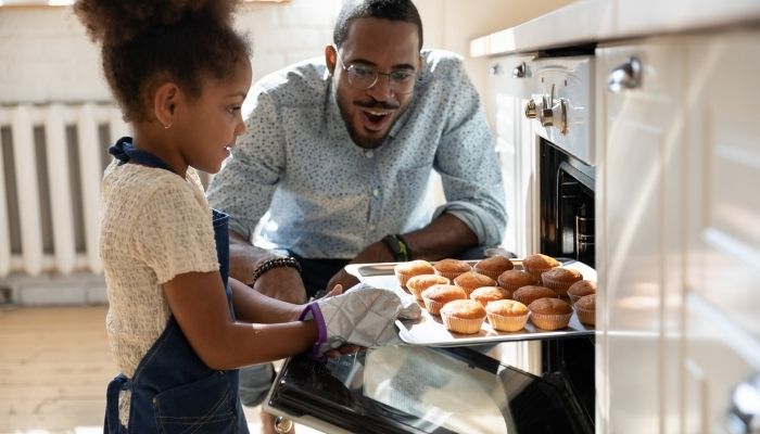 Father and daughter baking muffins