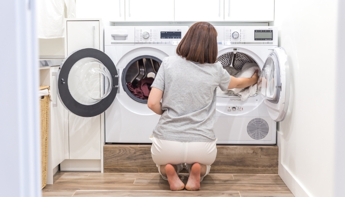 Woman transferring clothes to dryer