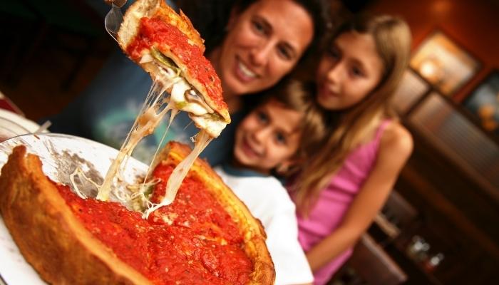 Family enjoying Chicago-style pizza