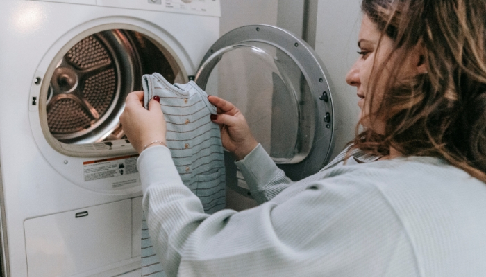 Woman pulling out baby clothes from washer