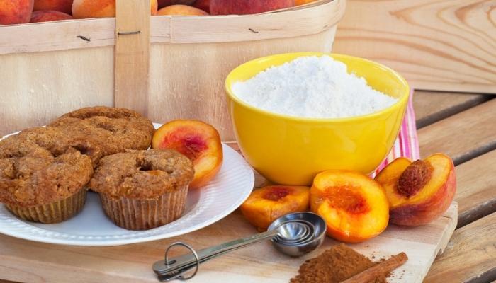 baking components and peach muffins on a table