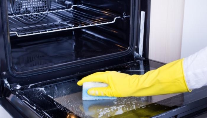 Person cleaning oven