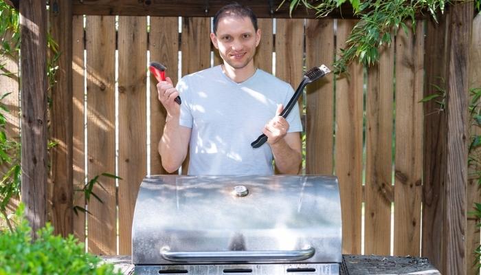 man ready to clean his gas grill