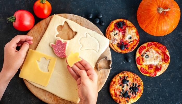 person making Halloween pizzas