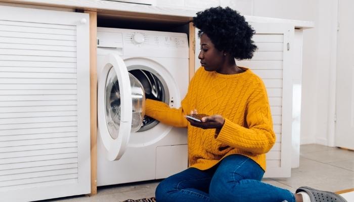 Woman adjusting washing machine