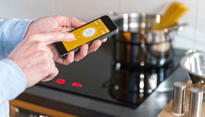 Closeup of someone using their smartphone to connect to cooking appliances