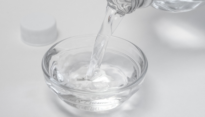 Closeup of white vinegar being poured into cup