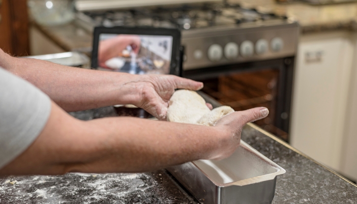 Closeup of someone learning to make bread before putting it into their gas range oven
