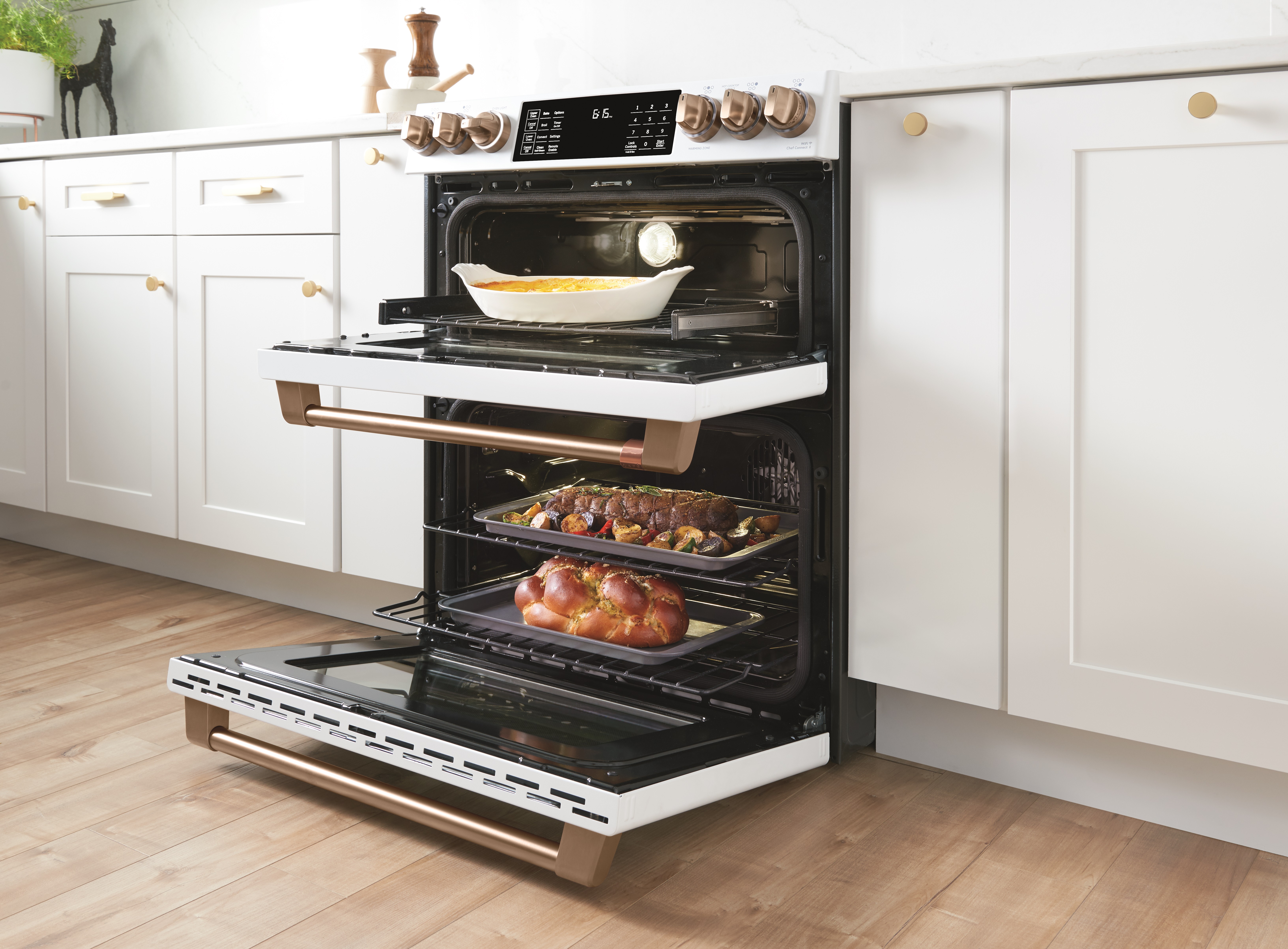 A double oven gas range with doors ajar and food cooking inside