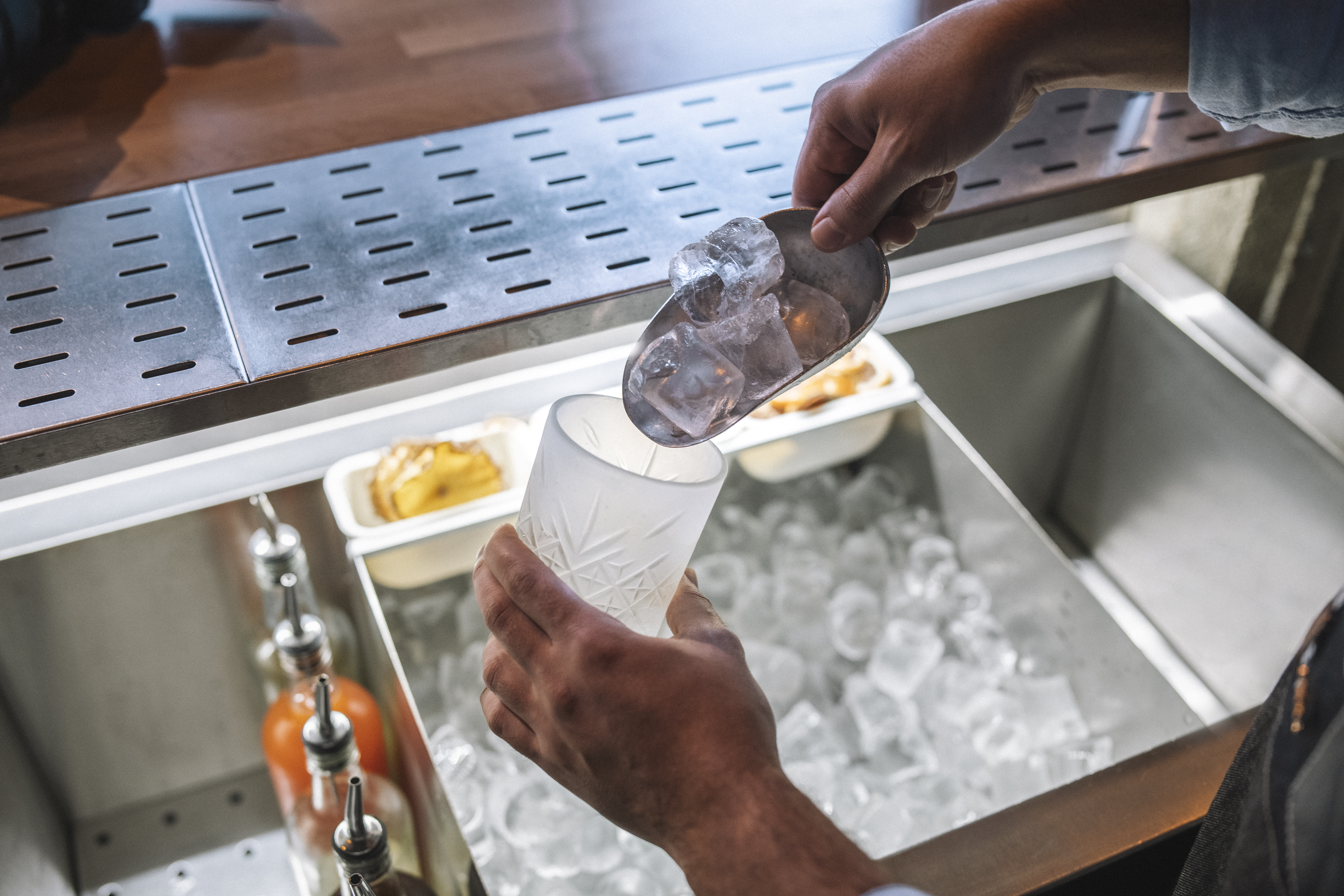 Person pouring ice into a cup from a built-in ice maker