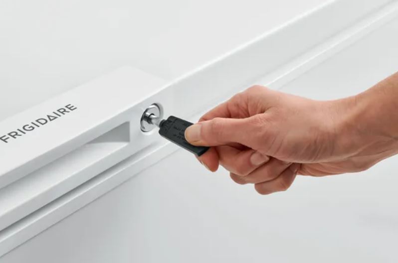 using a key to open the chest freezer 
