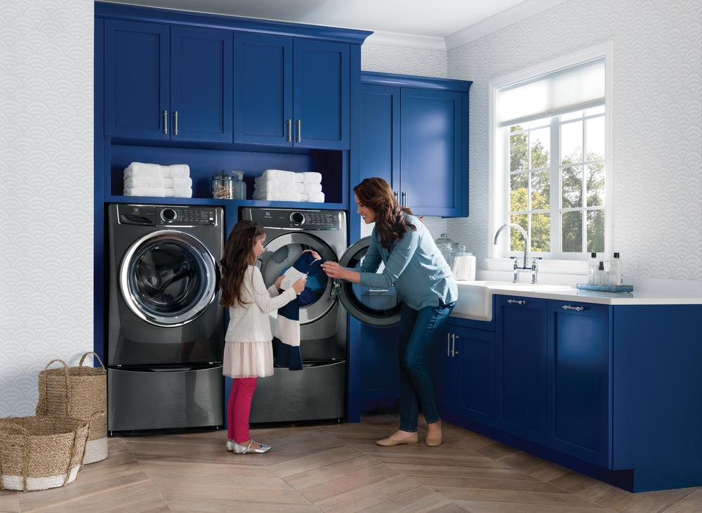 mother and daughter do laundry together with Electrolux washer and dryer pair
