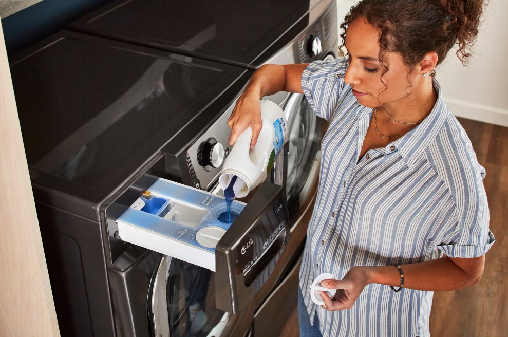 overhead shot of woman pouring in liquid detergent in dispenser of her LG washer