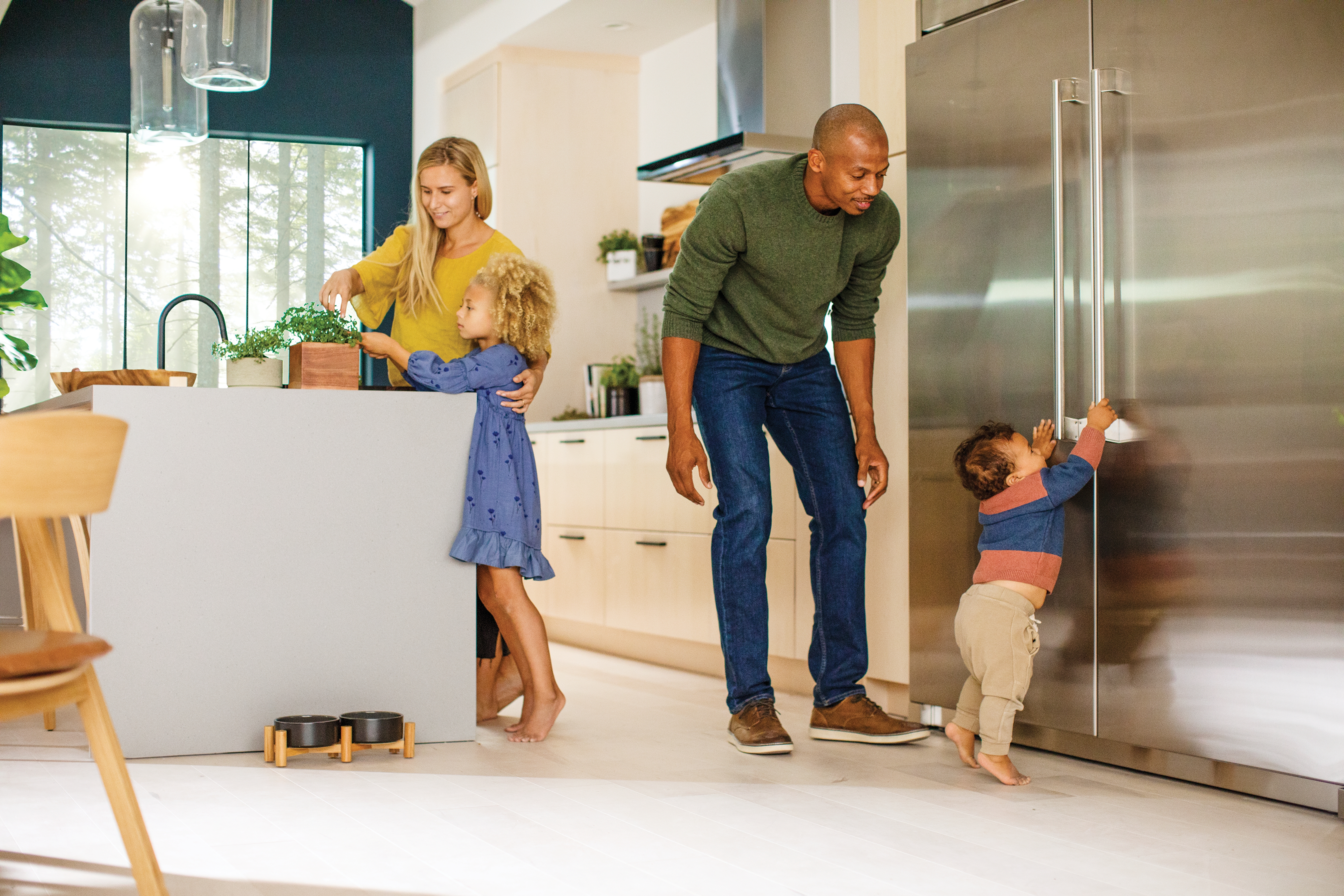 Father watches child opening an Electrolux built-in refrigerator 