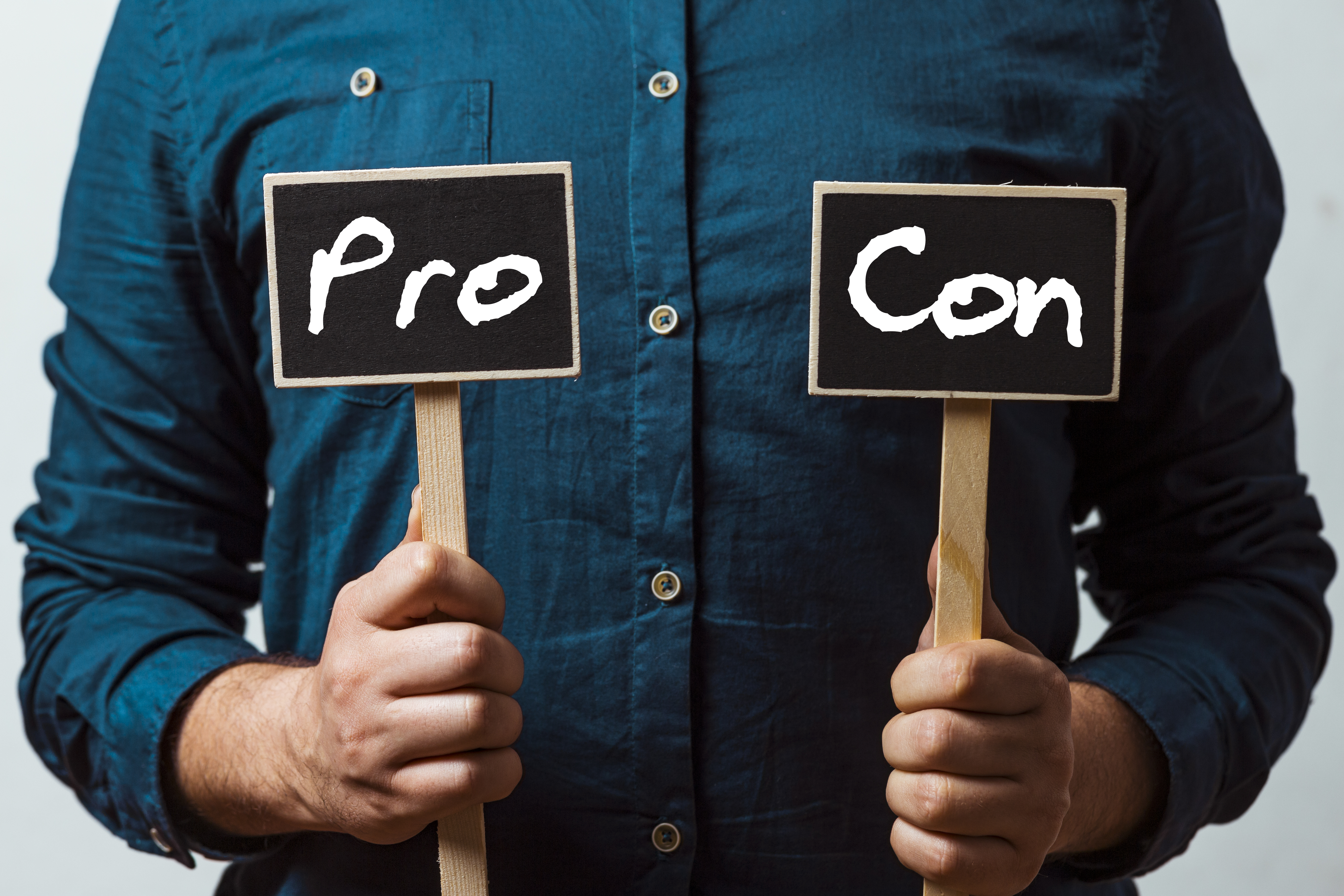 A man holding pro and con signs 