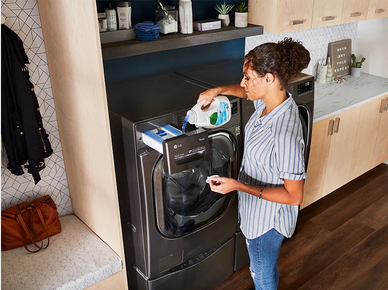 Woman pouring detergent into an LG front load washer 