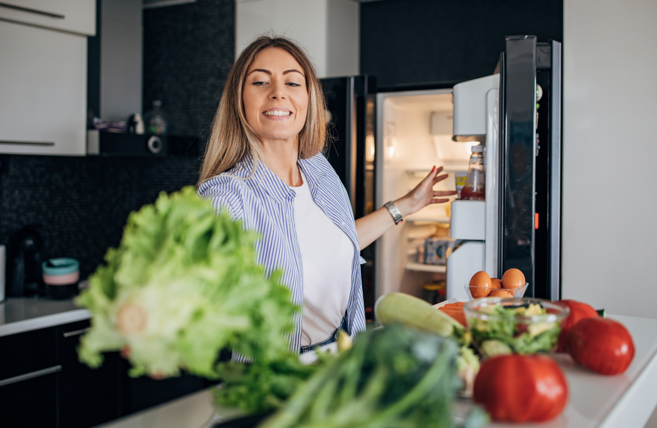 woman taking fresh veggies out of the fridge