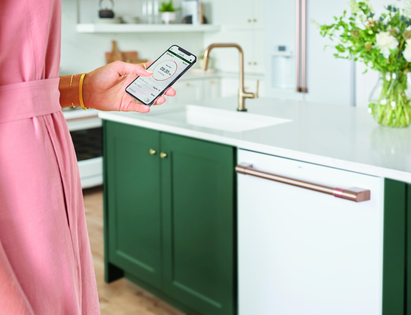 woman controls her matte white Café dishwasher with her smartphone
