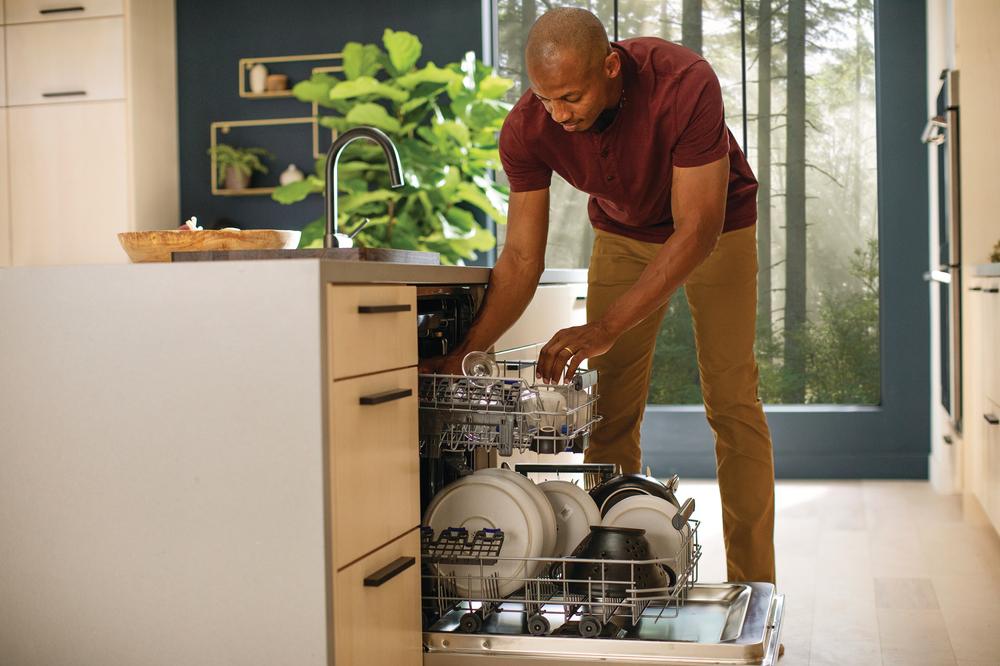 man unloads dishes from his Electrolux built-in-dishwasher