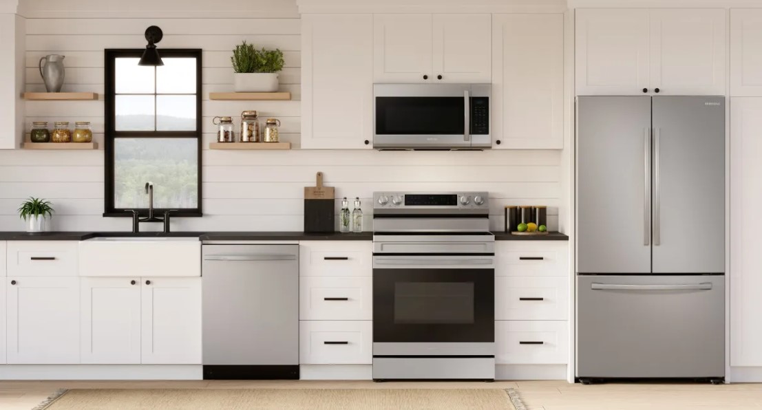 A kitchen with white cabinets and stainless steel Samsung kitchen appliances