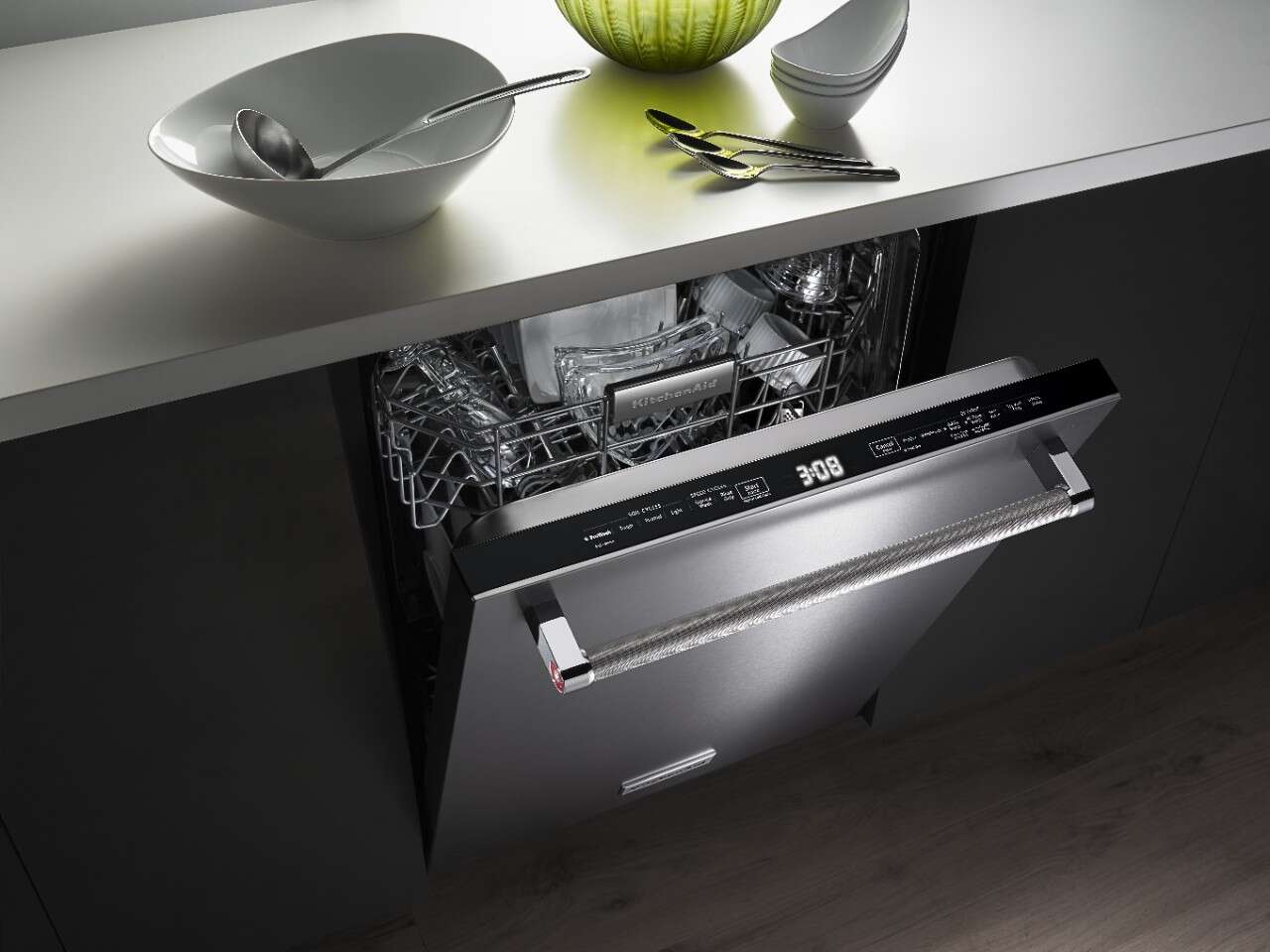 A KitchenAid kdtm704ess dishwasher shown with its door slightly open 