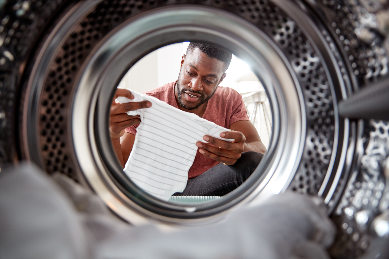 shot from inside dryer of man in red shirt with onesie
