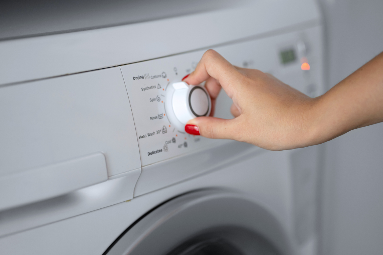 woman selecting dryer cycle using dryer rotary knob