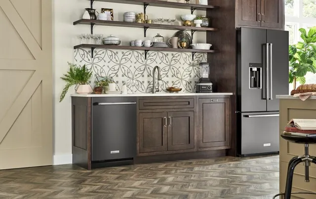 A kitchen featuring a KitchenAid black stainless steel dishwasher and refrigerator  