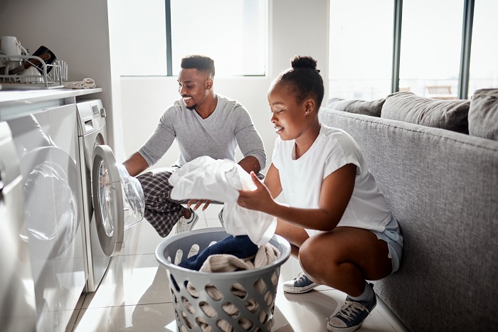 Shot of a happy young couple doing laundry together at home.