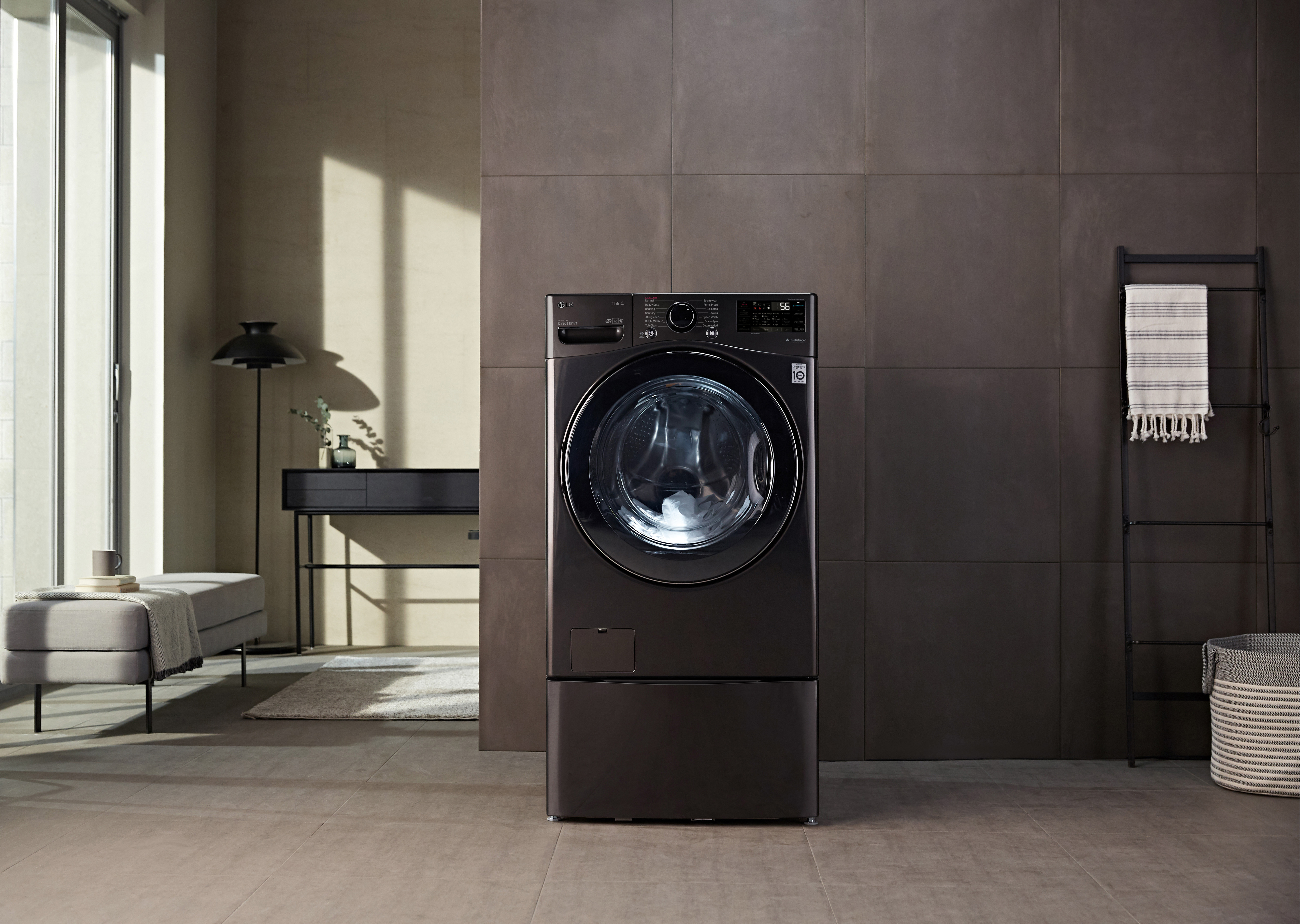 Lifestyle shot of black LG WM3998HBA washer dryer combo in living space