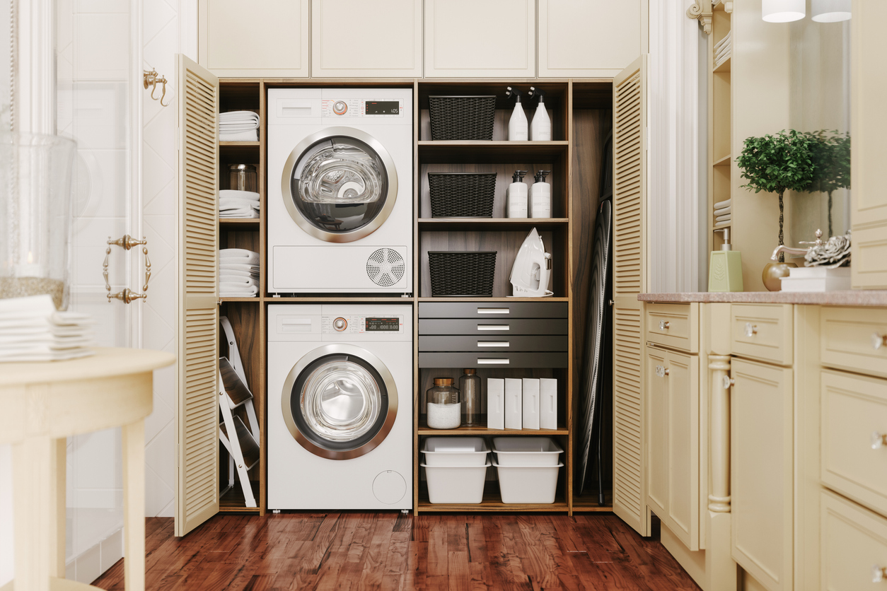Modern laundry room setup with a pair of stacked white laundry appliances.