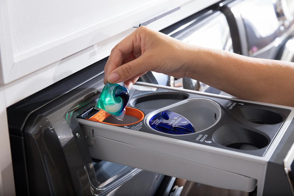  woman uses adaptive detergent dispenser on Electrolux front load washer