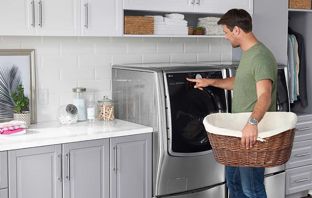man uses electric front controls on LG electric dryer
