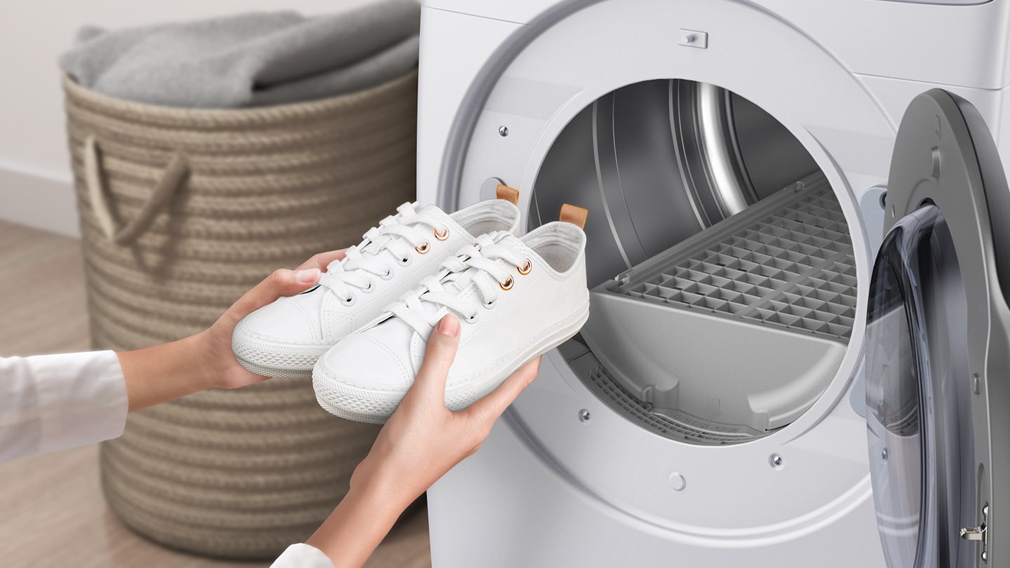 woman retrieves cleaned white sneakers from Samsung gas dryer