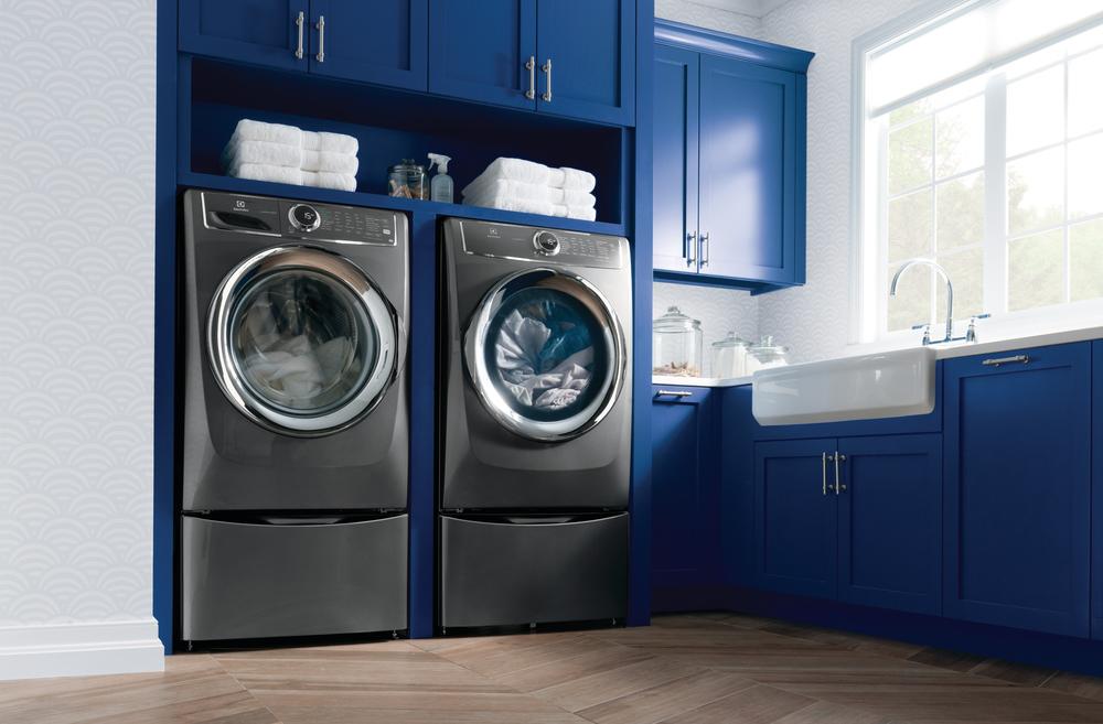 white and blue laundry room with large capacity washer and dryer