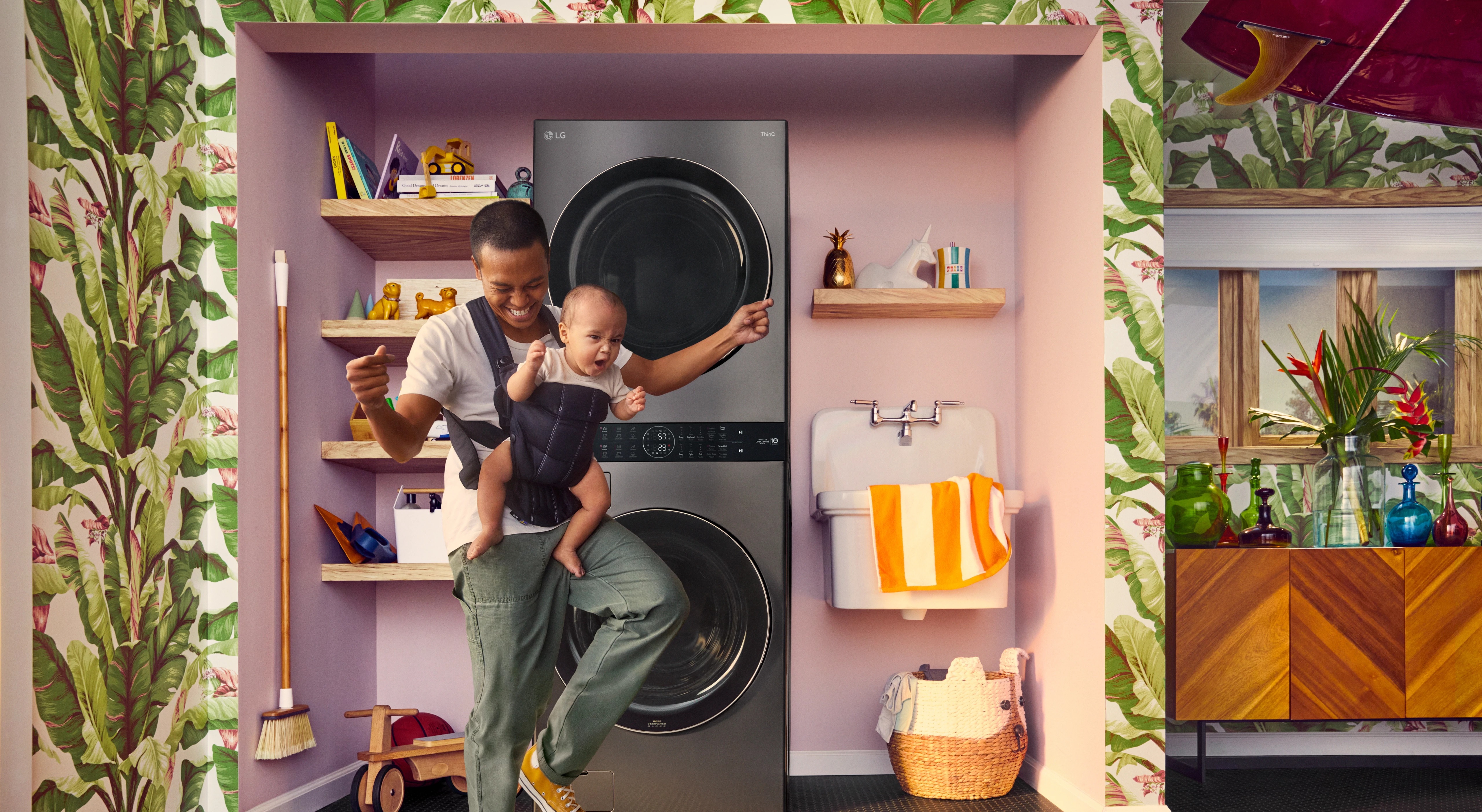  father rejoices with infant child in stylish laundry room with stackable LG washer and dryer