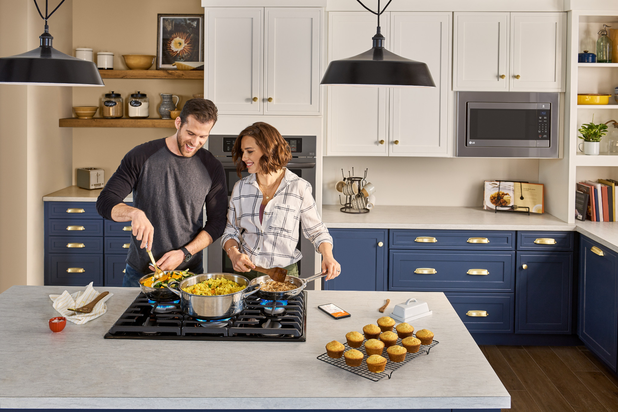 smiling couple make food on LG gas cooktop in their kitchen