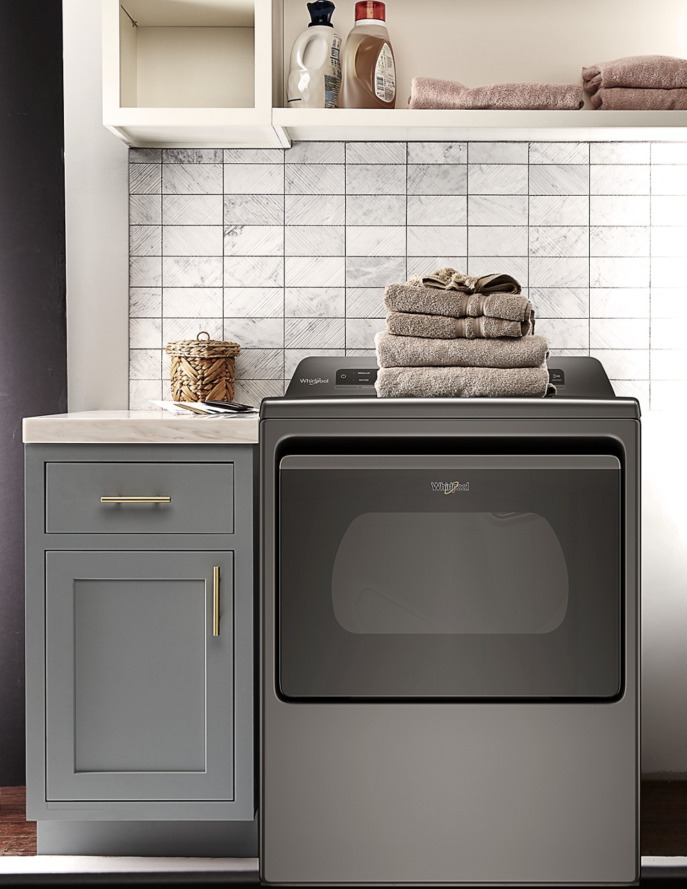Whirlpool dryer with stack of folded towels on top