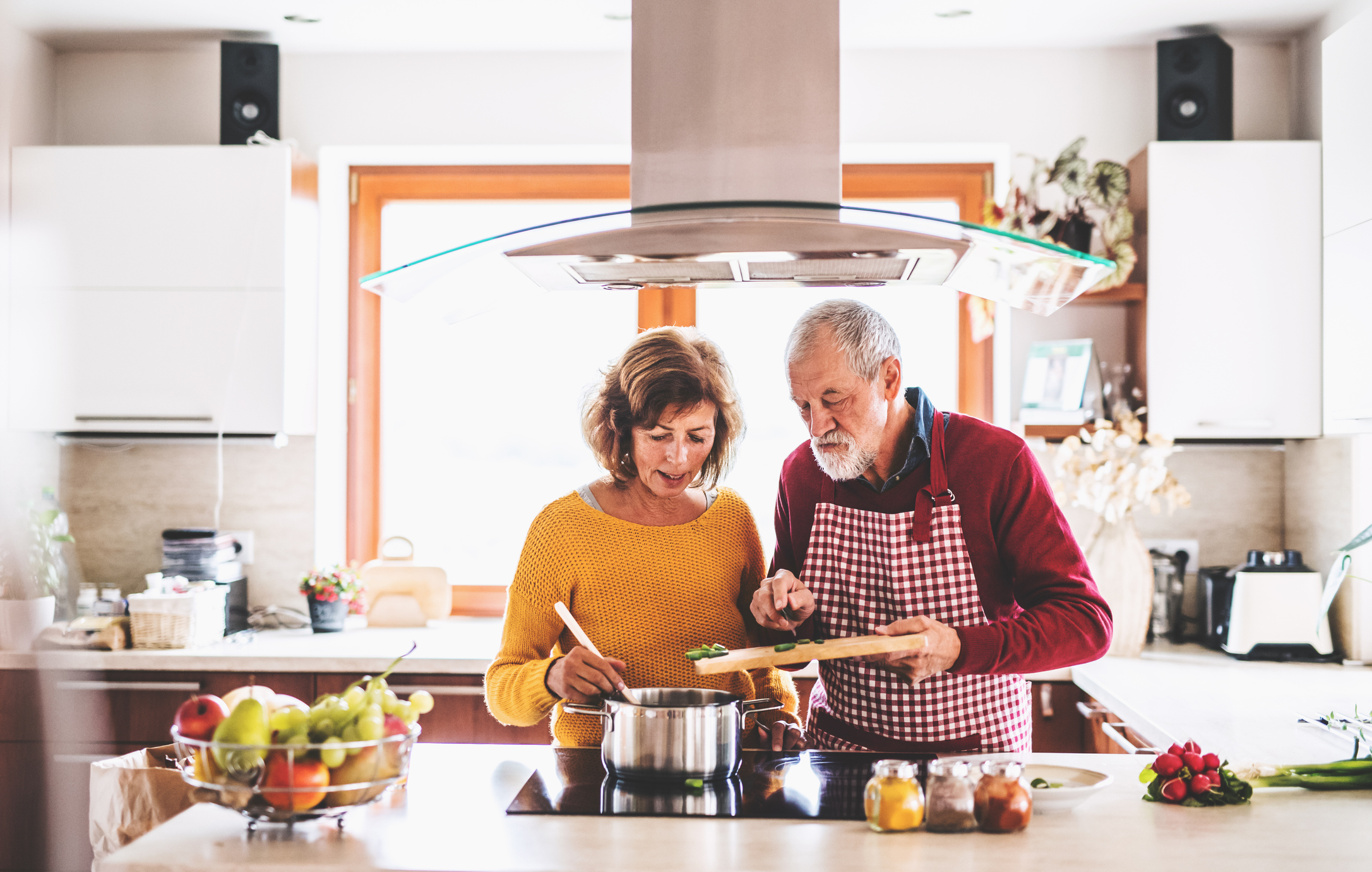 elderly couple in the kitchen making dinner