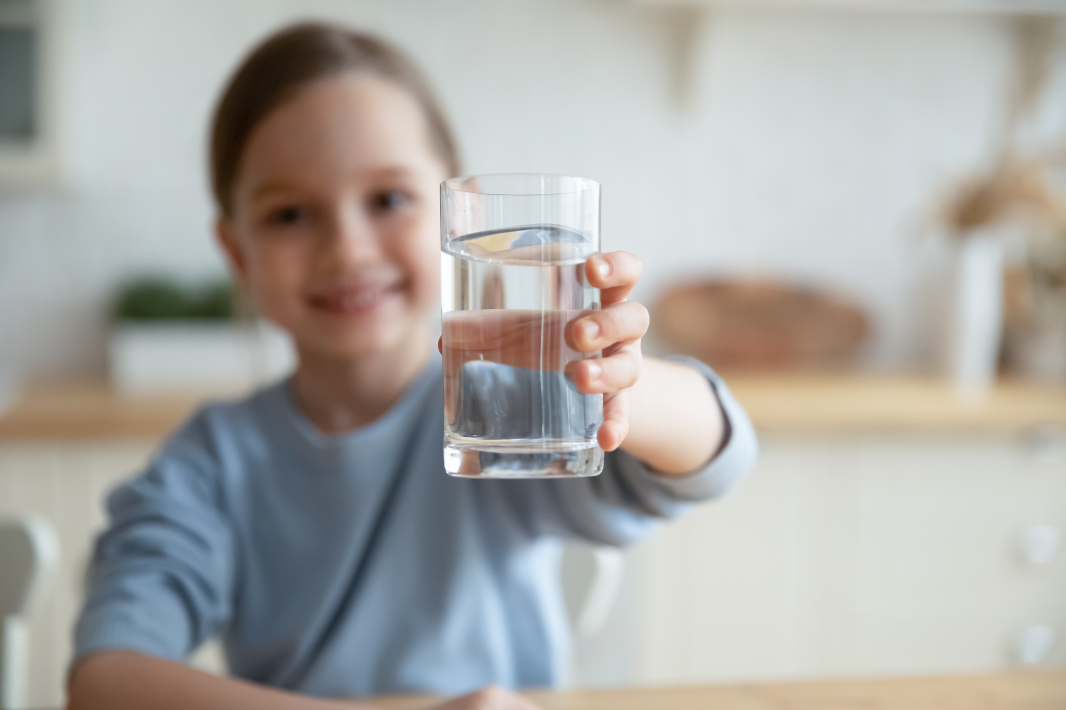 little girl holding fresh glass of water