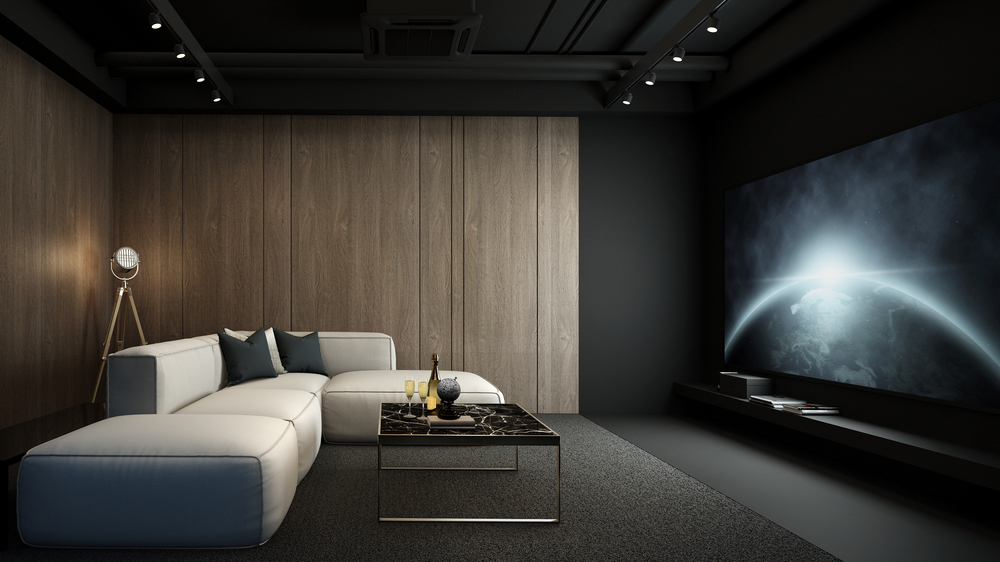 A modern sofa sits before a large screen in a recently updated home theater