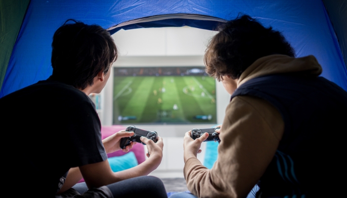 Two teen boys playing video games in one of their home’s zones