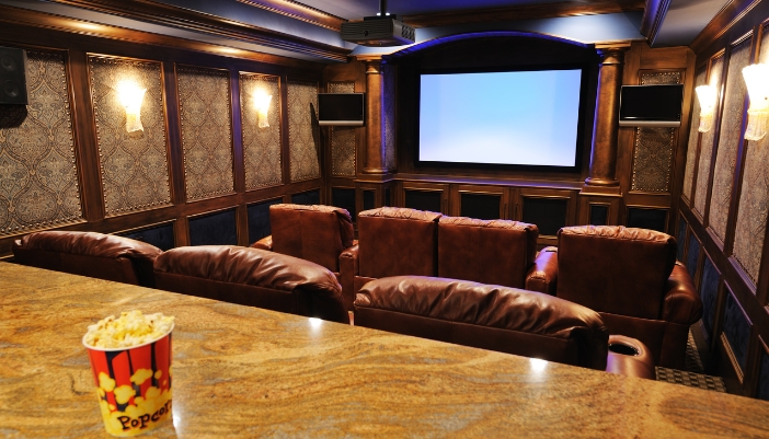 A dedicated home theater with a container of popcorn on the counter