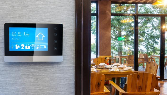 Closeup of a smart panel in front of a dining area of a restaurant