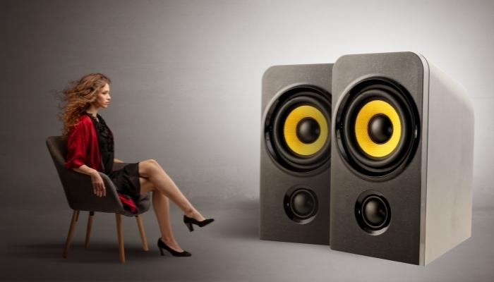 Woman sitting in front of huge speakers