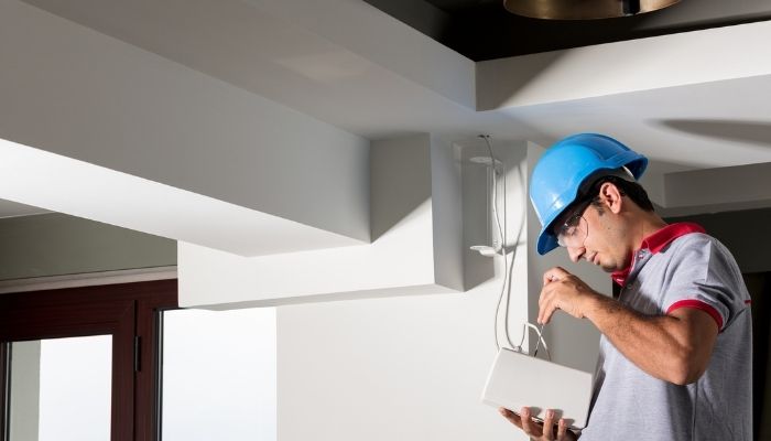 man installing ceiling speakers